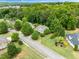 An aerial view of a property with mature trees, manicured lawns, and lush landscaping at 94 Fawn Hill Ct, Garner, NC 27529