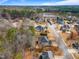 Aerial view of a residential neighborhood with mature trees surrounding houses and a small lake nearby at 94 Fawn Hill Ct, Garner, NC 27529