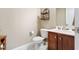 Bathroom features tile floors, wooden cabinets, and decorative wall shelving at 94 Fawn Hill Ct, Garner, NC 27529