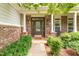 Inviting front door with brick columns, decorative lighting, and a well-maintained garden at 94 Fawn Hill Ct, Garner, NC 27529