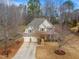 Inviting two-story home with a three-car garage, classic siding, a covered porch, and established trees at 94 Fawn Hill Ct, Garner, NC 27529