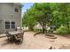 Back patio with a stone fire pit, grill and outdoor dining set surrounded by lush landscaping at 94 Fawn Hill Ct, Garner, NC 27529