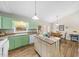 Charming kitchen features green cabinetry, stainless steel appliances, and a central island at 1008 Torredge Rd, Durham, NC 27712