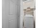 Compact laundry area with a front-loading washing machine and overhead storage shelves at 1008 Torredge Rd, Durham, NC 27712