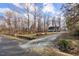 Long gravel driveway leads to house in a wooded lot with a blue sky overhead at 1008 Torredge Rd, Durham, NC 27712