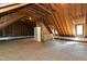 Spacious attic with exposed wood framing, a window, and a door at 102 Legault Dr, Cary, NC 27513