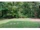 Backyard with stepping stones and surrounded by lush greenery and mature trees at 102 Legault Dr, Cary, NC 27513