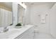Bright bathroom featuring dual sinks, modern fixtures, and white tile flooring at 102 Legault Dr, Cary, NC 27513