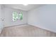 A bright bedroom features neutral decor and a view of the tree-lined property at 102 Legault Dr, Cary, NC 27513