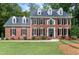 A stately two-story brick home with black shutters and a well-manicured front lawn at 102 Legault Dr, Cary, NC 27513