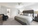 A spacious main bedroom features a gray upholstered bed, sitting area, and ensuite bathroom at 102 Legault Dr, Cary, NC 27513