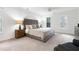 A bright main bedroom features neutral decor, recessed lighting, and natural light from two windows at 102 Legault Dr, Cary, NC 27513