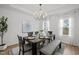 Elegant dining room with modern chandelier, neutral decor, and large windows at 1026 Janiskee Rd, Durham, NC 27703