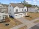 Two-story home featuring a two-car garage, a welcoming front porch, and well-maintained landscaping at 1026 Janiskee Rd, Durham, NC 27703
