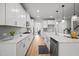 Modern white kitchen features stainless steel appliances, white cabinets, marble countertops and eat in island at 1026 Janiskee Rd, Durham, NC 27703