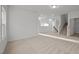 A bright living room featuring neutral carpet and fresh paint at 1026 Janiskee Rd, Durham, NC 27703
