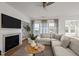 Bright living room features a fireplace and large windows, flooding the space with natural light at 1026 Janiskee Rd, Durham, NC 27703