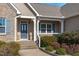 Charming front porch with blue door, decorative columns, and lush landscaping, inviting guests to enter at 1028 Allaire Dr, Raleigh, NC 27603