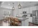 Open kitchen with white cabinets, granite countertops, a central island with seating, and stainless steel appliances at 1028 Allaire Dr, Raleigh, NC 27603