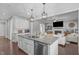 Open kitchen with granite island, stainless appliances and view into the living room at 1028 Allaire Dr, Raleigh, NC 27603