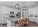 Modern kitchen featuring white cabinets, granite countertops, stainless steel appliances, and a functional island with seating at 1028 Allaire Dr, Raleigh, NC 27603