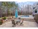 Inviting backyard with patio, outdoor dining set, waterfall feature, and view of the beautiful pool and landscaping at 108 Springfield Pl, Hillsborough, NC 27278