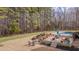Large backyard with pool, patio with dining, waterfall feature, and mature trees, perfect for outdoor living and entertainment at 108 Springfield Pl, Hillsborough, NC 27278