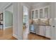 Butler's pantry features white cabinets, beverage fridge, tile backsplash, and stylish serving bar at 108 Springfield Pl, Hillsborough, NC 27278
