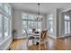 Sunlit dining area with a chandelier, hardwood flooring and large windows for natural light at 108 Springfield Pl, Hillsborough, NC 27278