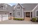 Close up of a gray home's entrance with stone steps and a three-car garage at 108 Springfield Pl, Hillsborough, NC 27278
