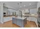 Gourmet kitchen with stainless steel appliances, center island, pendant lighting, and modern finishes at 108 Springfield Pl, Hillsborough, NC 27278