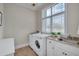 Functional laundry room with sink, granite counters, and ample natural light at 108 Springfield Pl, Hillsborough, NC 27278