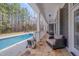Inviting covered patio perfect for relaxation with stone flooring and stylish outdoor seating near the pool at 108 Springfield Pl, Hillsborough, NC 27278