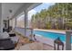 Serene covered patio with stone flooring, comfortable seating, and a view of the sparkling pool and lush landscape at 108 Springfield Pl, Hillsborough, NC 27278