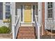 Inviting front entrance with brick steps leading to a bright yellow door, number 112 on the side at 112 Solstice Cir, Cary, NC 27513