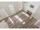 Sunlit living room with hardwood floors, a fireplace, ceiling fan, and views of the front entrance at 112 Solstice Cir, Cary, NC 27513