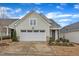 Charming home with light green siding, manicured lawn, and a two-car garage under a partly cloudy sky at 119 Canary Ct, Raleigh, NC 27610