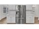 Stainless steel refrigerator with water dispenser, white cabinets and countertops, and subway tile backsplash at 119 Canary Ct, Raleigh, NC 27610
