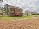 Spacious brick house with a large backyard, a raised red deck, and a tree-lined property at 1201 Clematis St, Knightdale, NC 27545
