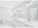 An all-white bathroom with marble-look floors and a dual sink vanity at 1201 Clematis St, Knightdale, NC 27545