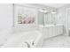 Bathroom with a tub, dual sink vanity, and marble-look floors and walls at 1201 Clematis St, Knightdale, NC 27545