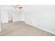 This bedroom features light gray walls and floors, a ceiling fan, and an entrance to another room at 1201 Clematis St, Knightdale, NC 27545