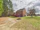 A spacious brick house with a large backyard, a raised red deck, and many tall trees at 1201 Clematis St, Knightdale, NC 27545