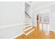 A foyer with hardwood floors and light-colored walls, leading to a staircase and a view of another room at 1201 Clematis St, Knightdale, NC 27545