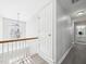 Hallway landing featuring wood railing, gray flooring and an ornate light fixture at 1201 Clematis St, Knightdale, NC 27545