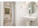 Bathroom featuring pedestal sink, neutral colors, and a view of a shower/tub with tiled surround at 1224 Manchester Dr, Raleigh, NC 27609