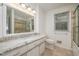 A bright bathroom with white cabinets, granite countertops, and a tiled shower with glass door at 1224 Manchester Dr, Raleigh, NC 27609