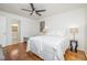Comfortable bedroom featuring hardwood floors, ceiling fan, two windows, and access to ensuite bath at 1224 Manchester Dr, Raleigh, NC 27609