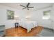 Bright bedroom featuring hardwood floors, two windows, ceiling fan, and neutral decor at 1224 Manchester Dr, Raleigh, NC 27609