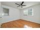 A well-lit bedroom featuring hardwood floors, two windows, and neutral ceiling fan at 1224 Manchester Dr, Raleigh, NC 27609